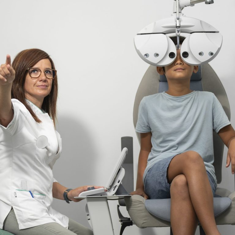 Young Asian boy with a modern phoropter at an optometrist consultation with an optometrist woman.